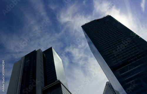 Landscape of two skyscrapers with different designs standing under the blue sky