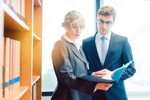 Cuadro en lienzo Senior and junior lawyer in law firm discussing strategy in a case
