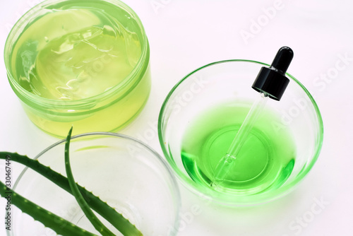 Aloe gel, aloe vera leaves and green serum from natural ingredients on a white background. Making cosmetics at home