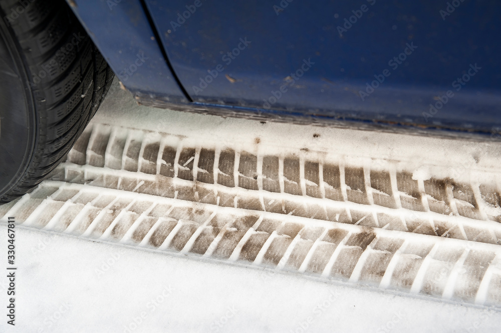 Close up of a car and winter tires. Very dirty car is parked on the street covered by snow. Close up of a car and winter tires. Very dirty car is parked on the street covered by snow.