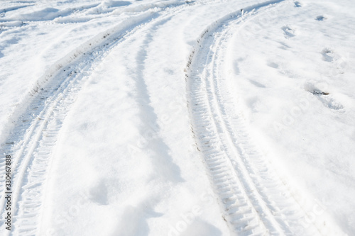 Tire tracks on a road covered by snow. Cold winter day. © diesirae