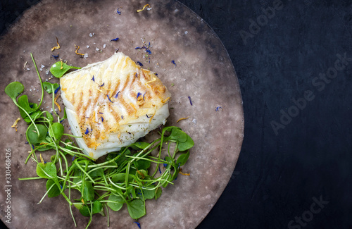 Konstfotografi Gourmet fried European skrei cod fish filet with purslane lettuce and herbs as t
