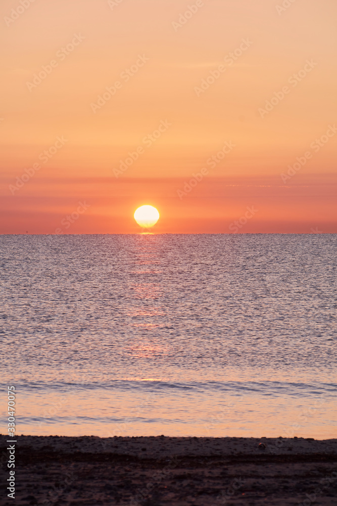 Sunrise on the beach with the sun rising.