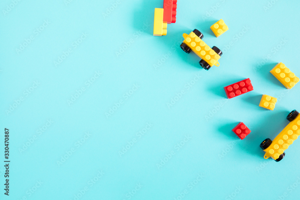 Kids toys and colorful blocks on blue background. Flat lay, top view, copy space