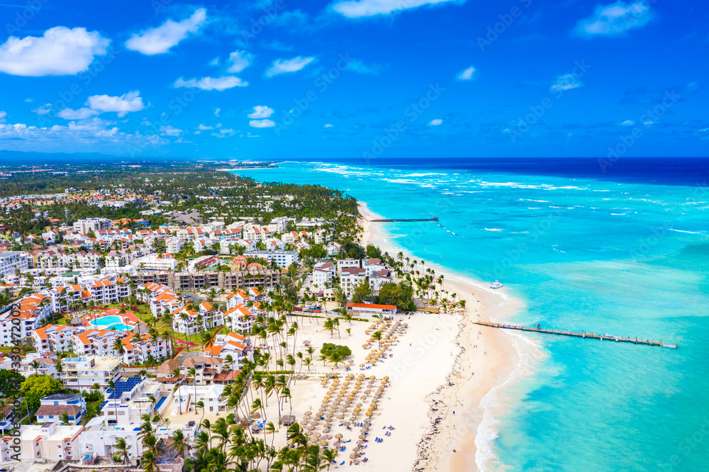 Aerial drone view of beautiful caribbean tropical beach with palms and straw umbrellas. Bavaro, Punta Cana, Dominican Republic. Vacation background.