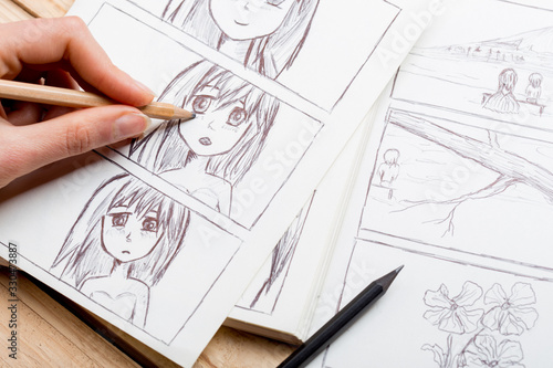 Artist drawing an anime comic book in a studio. photo