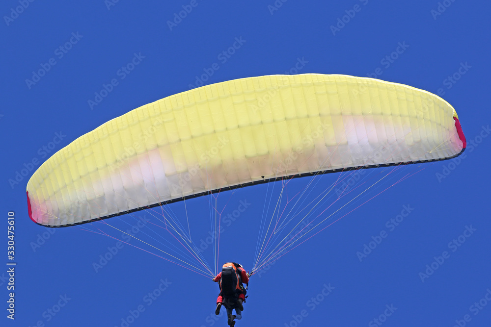 Paraglider flying wing in a blue sky Paraglider flying wing in a blue sky