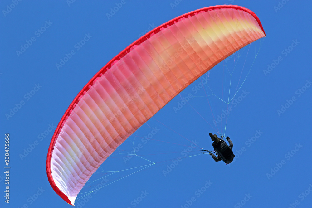 Paraglider flying wing in a blue sky Paraglider flying wing in a blue sky