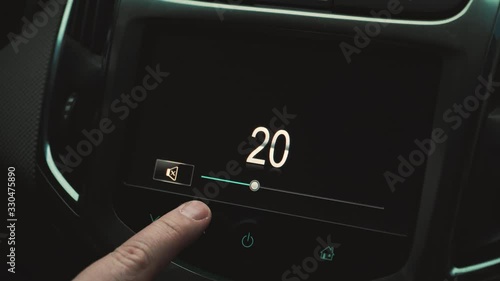 the man turns the sound up and down in the car