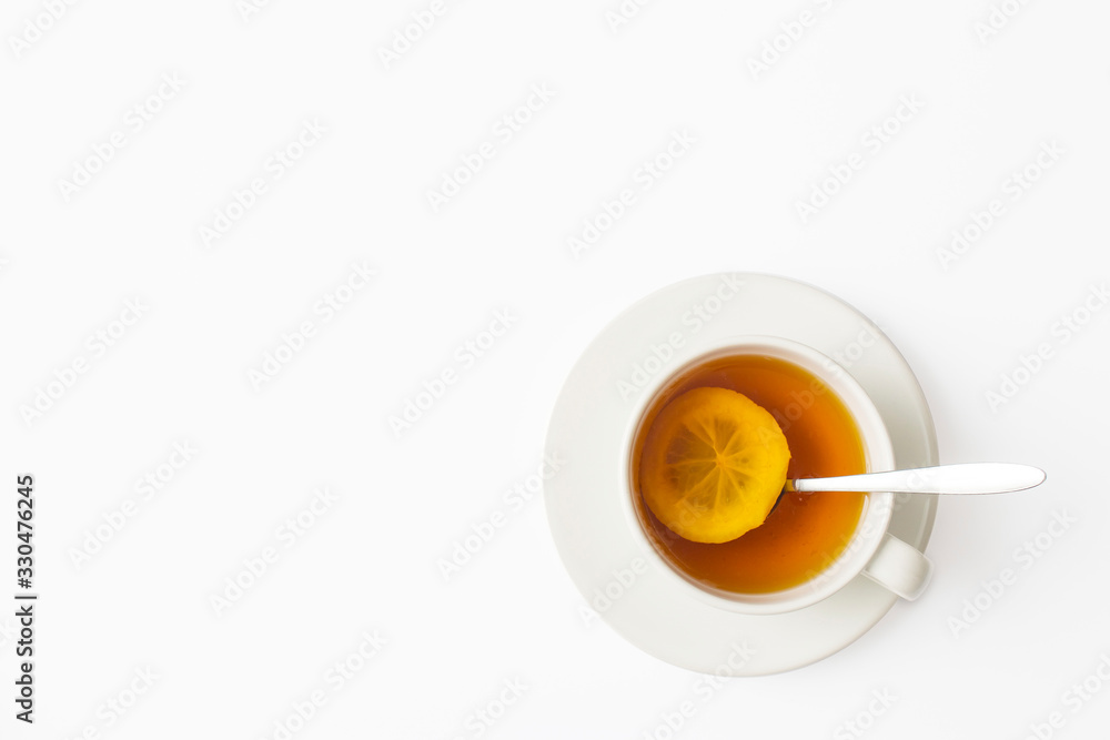 White cup of tea with lemon with a saucer and a spoon on a white table. Square frame. Copy space White cup of tea with lemon with a saucer and a spoon on a white table. Square frame. Copy space