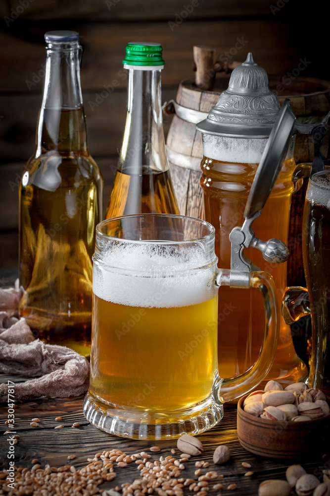 Light frothing beer in a glass, on an old background. Light frothing beer in a glass, on an old background.