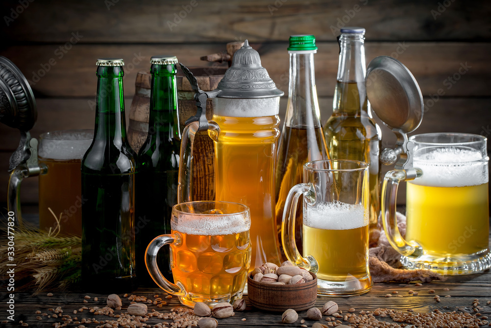 Fototapeta premium Light frothing beer in a glass, on an old background.