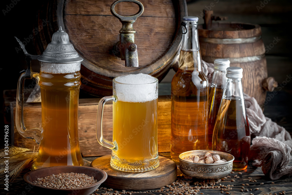 Light frothing beer in a glass, on an old background. Light frothing beer in a glass, on an old background.
