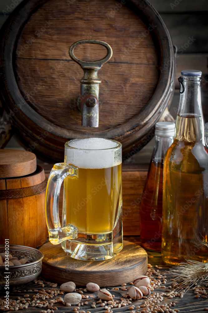 Light frothing beer in a glass, on an old background. Light frothing beer in a glass, on an old background.