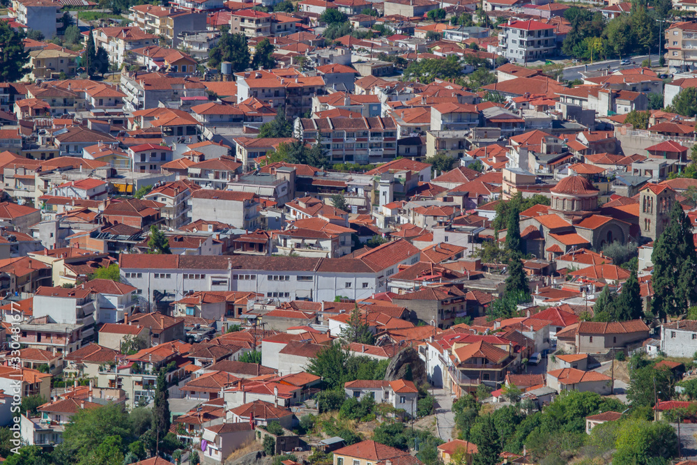 Greece. White buildings with red roofs. Many low-rise residential buildings and a Church. Panorama of Greece from a height. Aerial view of the Greek city. Residential areas of the Greek city.