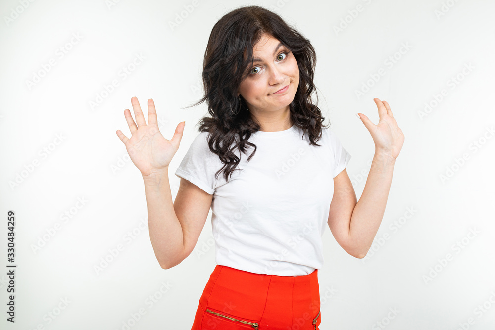 brunette girl in a white t-shirt worries about a problem on a white studio background brunette girl in a white t-shirt worries about a problem on a white studio background