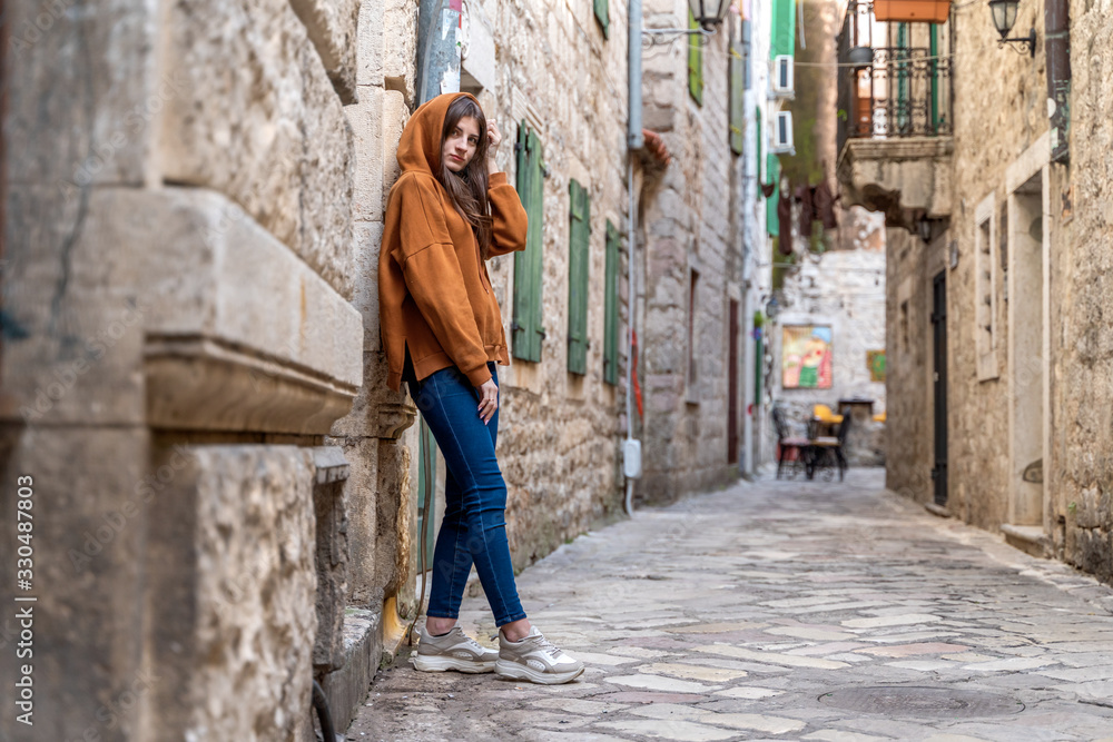 Beautiful fashion woman outdoor on the street of the old town in Kotor, Montenegro