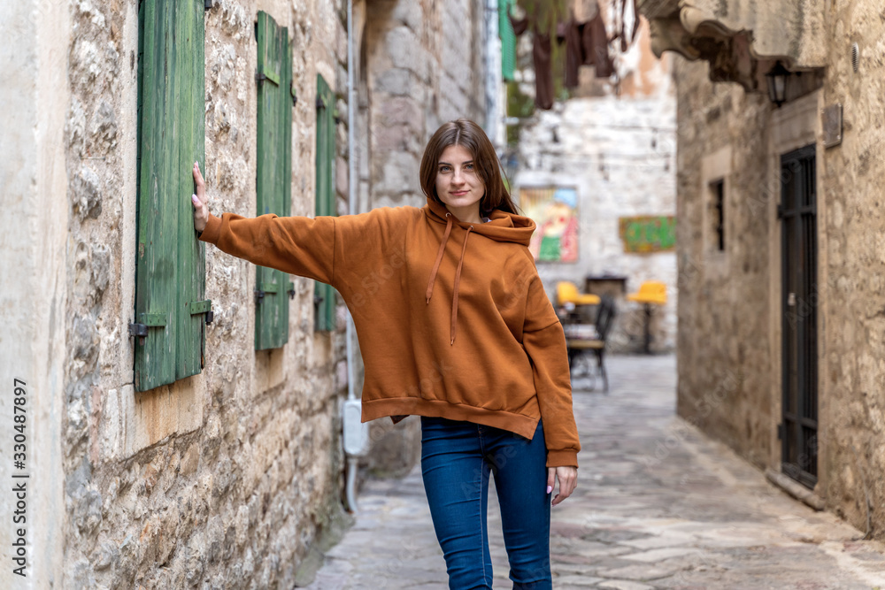 Beautiful fashion woman outdoor on the street of the old town in Kotor, Montenegro