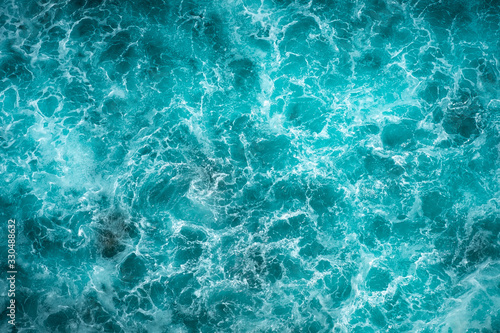 Texture Light blue surface of raging sea water with white foam and wave pattern