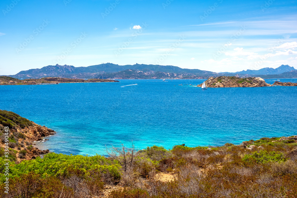 Fototapeta premium Caprera Island and Spiaggia di Cala Portese harbor at the Tyrrhenian Sea coastline with Isola Porco island, La Maddalena archipelago and the Sardinian mainland in background in Sardinia, Italy