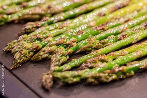 tender green asparagus on black metal plate. Healthy and natural grilled food. Background