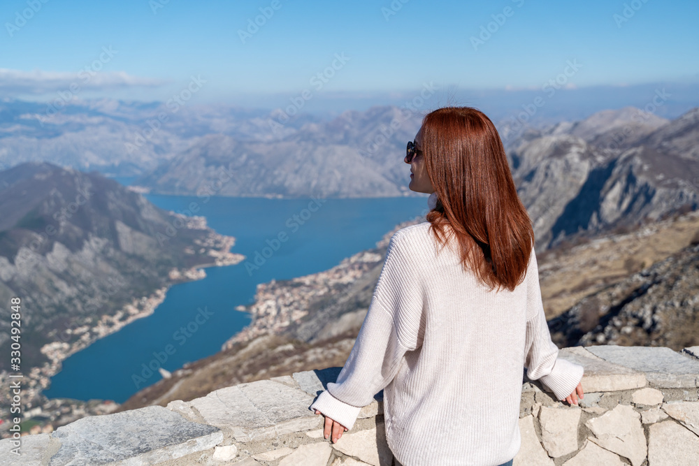 Young girl admiring the scenery from the viewpoint in Montenegro