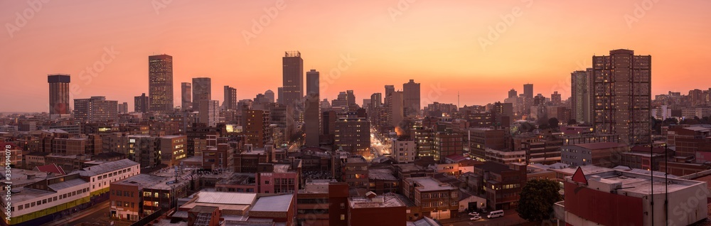 Fototapeta premium Piękne i dramatyczne zdjęcie panoramiczne panoramy miasta Johannesburg, wykonane w złoty wieczór po zachodzie słońca.