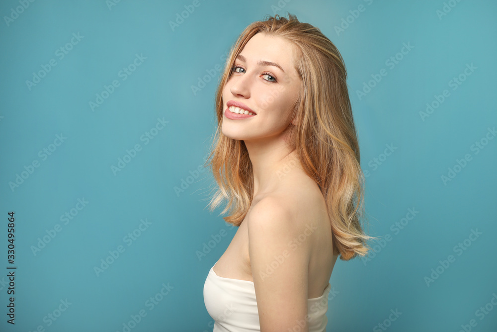 Portrait of beautiful smiling woman on blue background