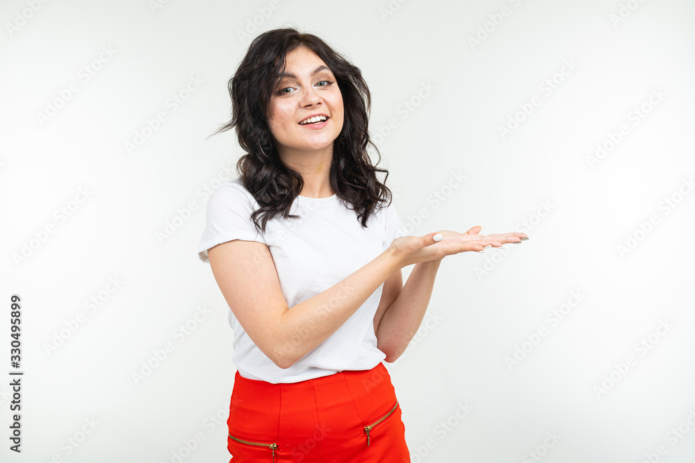 close-up of a brunette girl in a white T-shirt with holding hands on a white studio background close-up of a brunette girl in a white T-shirt with holding hands on a white studio background