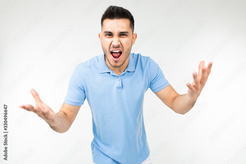 handsome guy in a blue t-shirt screaming at the camera on a white isolated background handsome guy in a blue t-shirt screaming at the camera on a white isolated background