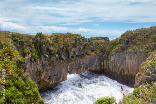 Blow hole in the pancake rocks, layers of eroded limestone, in Punakaiki, Paparoa National Park, South Island, New Zealand 