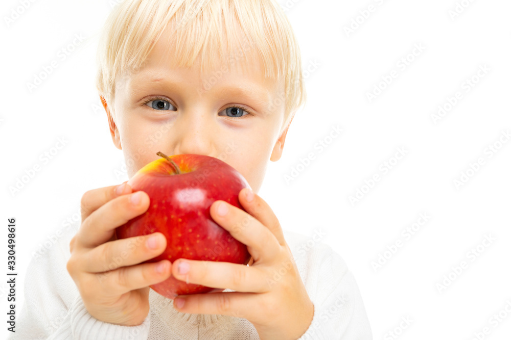 Little beautiful boy with blonde hair eats an apple, picture isolated on white background Little beautiful boy with blonde hair eats an apple, picture isolated on white background