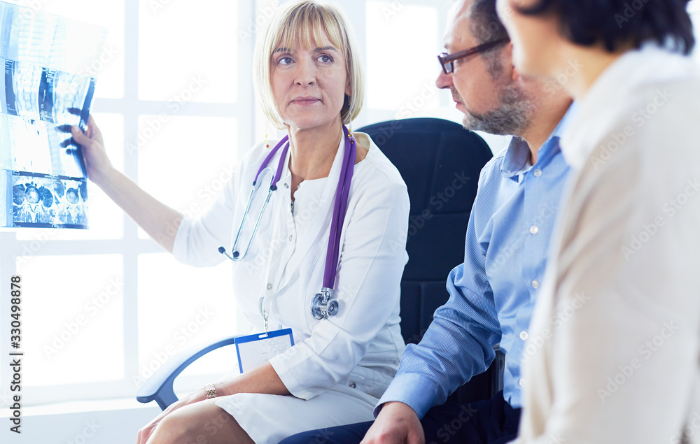 Doctor woman explaining x-ray results to patient Doctor woman explaining x-ray results to patient