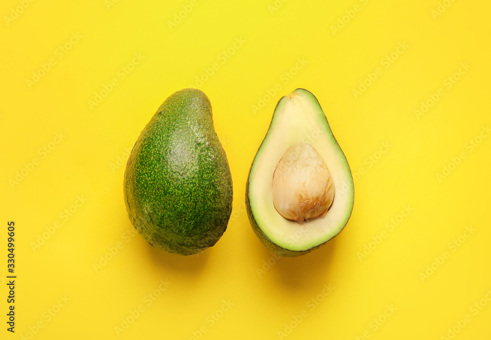 Green ripe avocado on yellow background. Top view