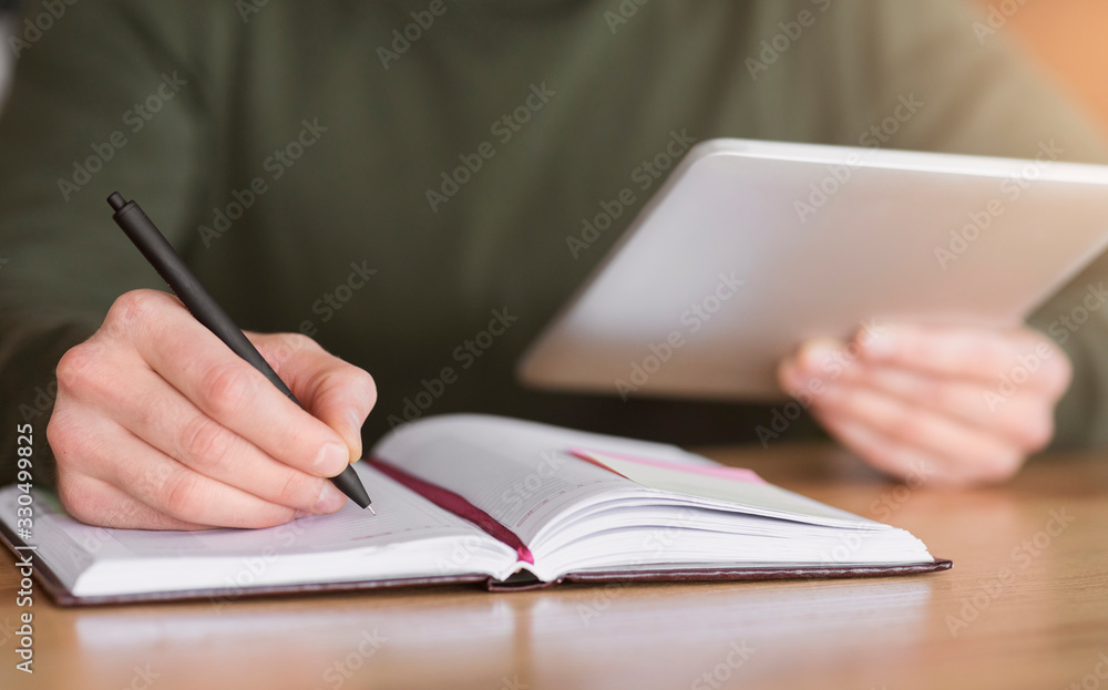 Man hands taking notes and holding digital tablet Man hands taking notes and holding digital tablet