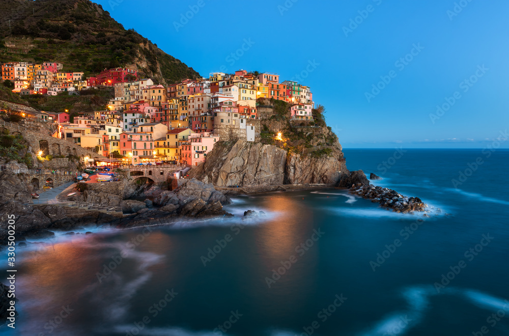 Panoramic sunset view of beautiful town of Manarola - one of five famous colorful villages of Cinque Terre National Park in Italy, Liguria region.