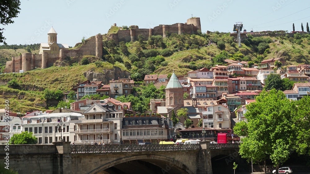 Obraz premium View towards Metekhi Bridge and the Old Town district of Tbilisi, the capital city of Georgia in Eastern Europe. Georgia, Tbilisi - June 2019