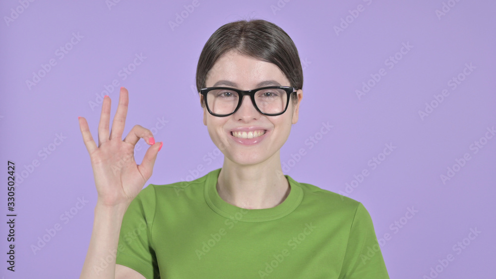 The Young Woman showing Ok Sign on Purple Background
