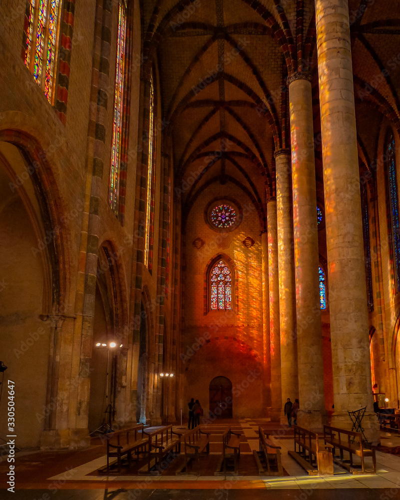 Toulouse, France - CIRCA 2010. Inside a Catholic church in the Ville Rose. Stained glass makes colorful and mystical reflections at the columns. 