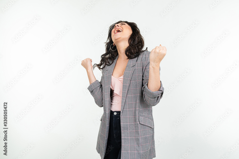 joyful girl in a classic gray jacket is jumping with happiness on a white background joyful girl in a classic gray jacket is jumping with happiness on a white background