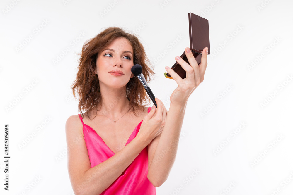 A young caucasian woman do makeup isolated on white background A young caucasian woman do makeup isolated on white background