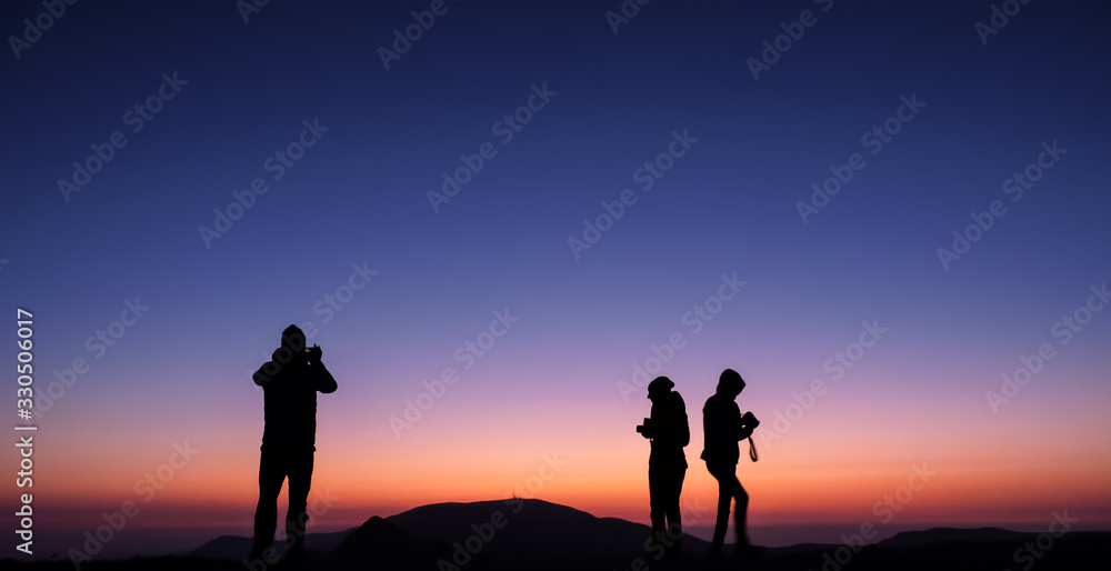 Ambaritsa peak, Bulgaria - October 20, 2019. Group of climbers welcoming the sunset from the top f Ambaritsa peak, Central Balkan national park. Botev peak at the bottom of the horizon.