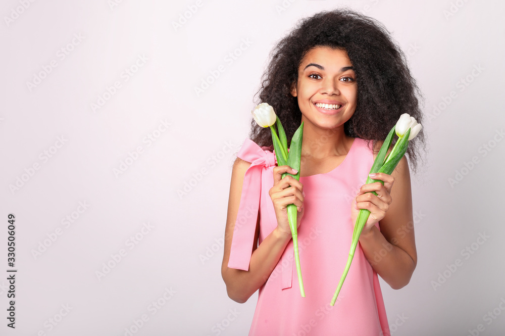 Young african woman with flowers on white background. Women's day concept Young african woman with flowers on white background. Women's day concept