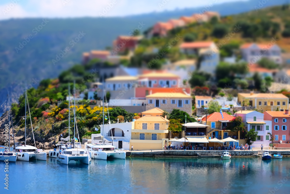 Soft focus and tilt shift  blur.  Colorful Asos village at Kefalonia island. Greece. Popular destination on Ionian Sea for vacation. Mediterranean port for traveling by yacht and honeymoon paradise