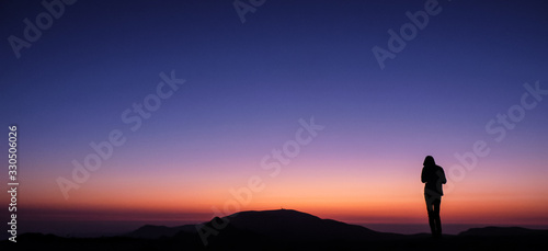 Ambaritsa peak, Bulgaria - October 20, 2019. Group of climbers welcoming the sunset from the top f Ambaritsa peak, Central Balkan national park. Botev peak at the bottom of the horizon.