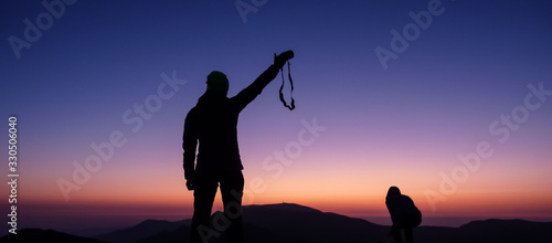 Ambaritsa peak, Bulgaria - October 20, 2019. Group of climbers welcoming the sunset from the top f Ambaritsa peak, Central Balkan national park. Botev peak at the bottom of the horizon.