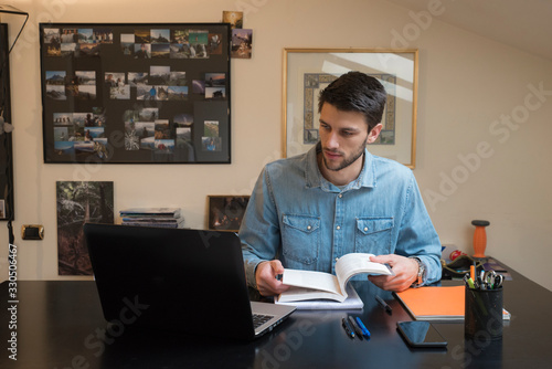 Young male studying for university at home via online lessons during the coronavirus quarantine. Distance education