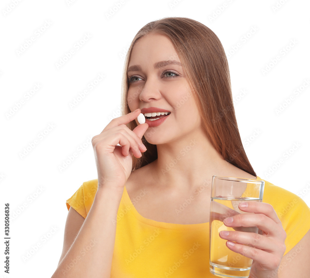 Young woman with glass of water taking vitamin pill on white background Young woman with glass of water taking vitamin pill on white background