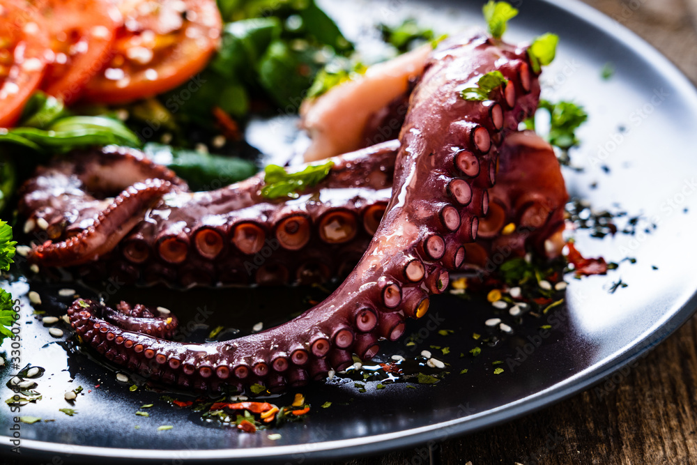 Fried octopus and vegetables on wooden table Fried octopus and vegetables on wooden table