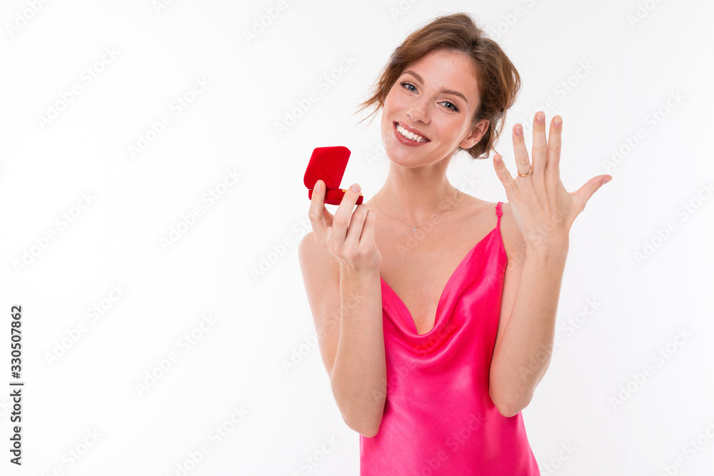 Young beautiful girl holds a box for a engagement ring and shows it on her hand isolated on white background Young beautiful girl holds a box for a engagement ring and shows it on her hand isolated on white background